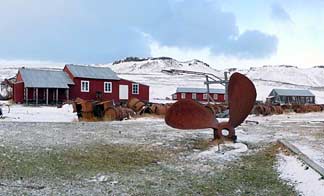 The buildings and a half-buried ship's propellor at Port Jeanne d'Arc.